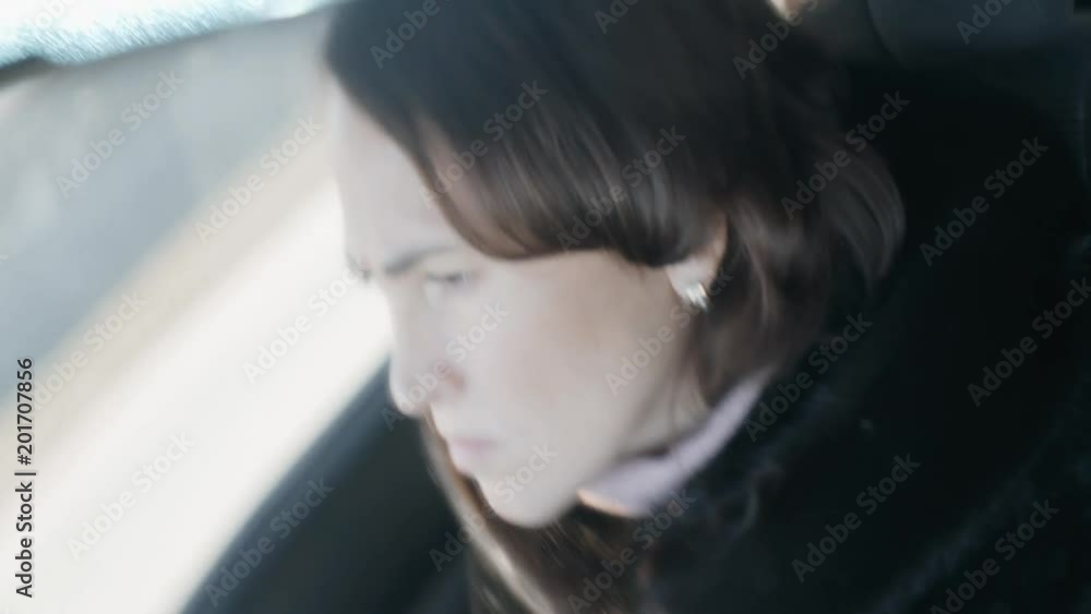 A woman in the reflection of the car's inside mirror. Woman driving. A woman in the reflection of the car's inside mirror. Woman driving.