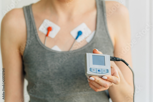 Woman wearing holter monitor device for daily monitoring of an electrocardiogram. Treatment of heart diseases photo
