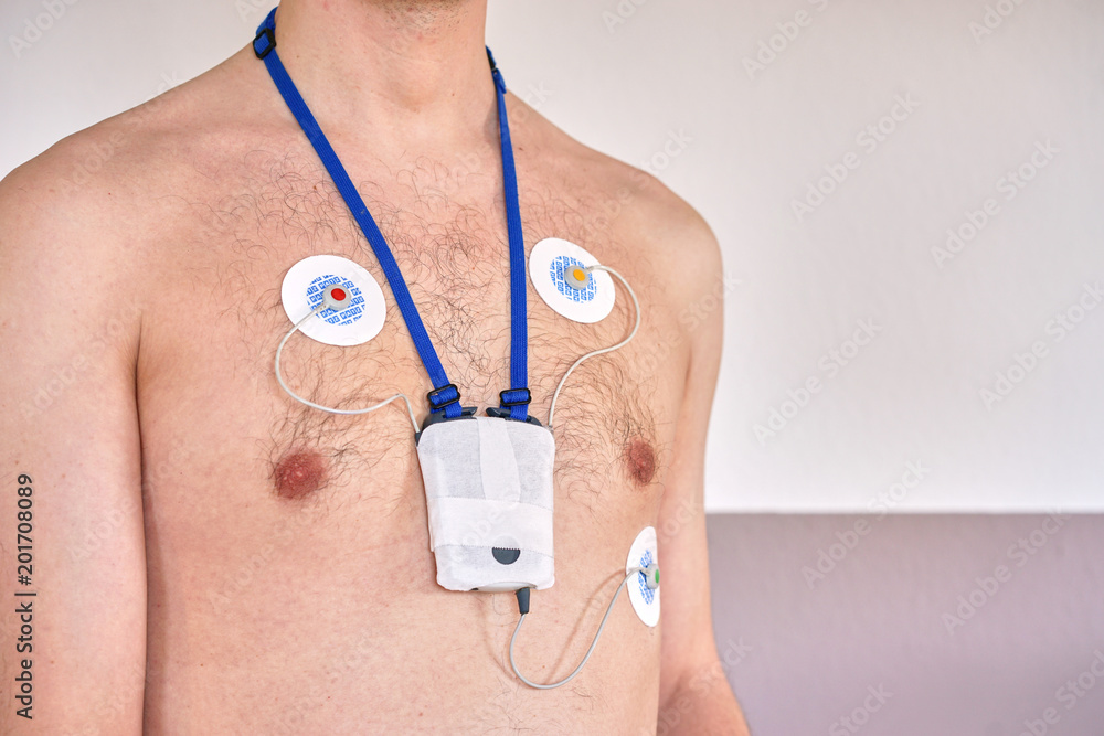 Fototapeta premium Man wearing 24 hrs electrocardiogram monitor device on his chest / heart investigation