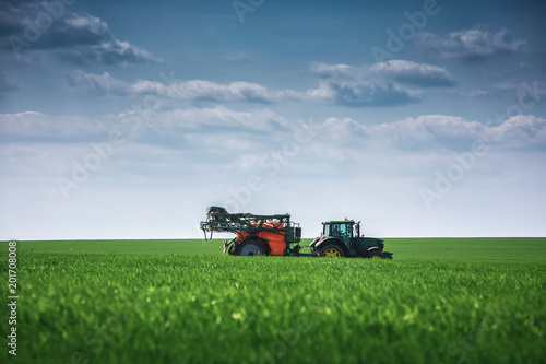 Farming tractor plowing and spraying on field