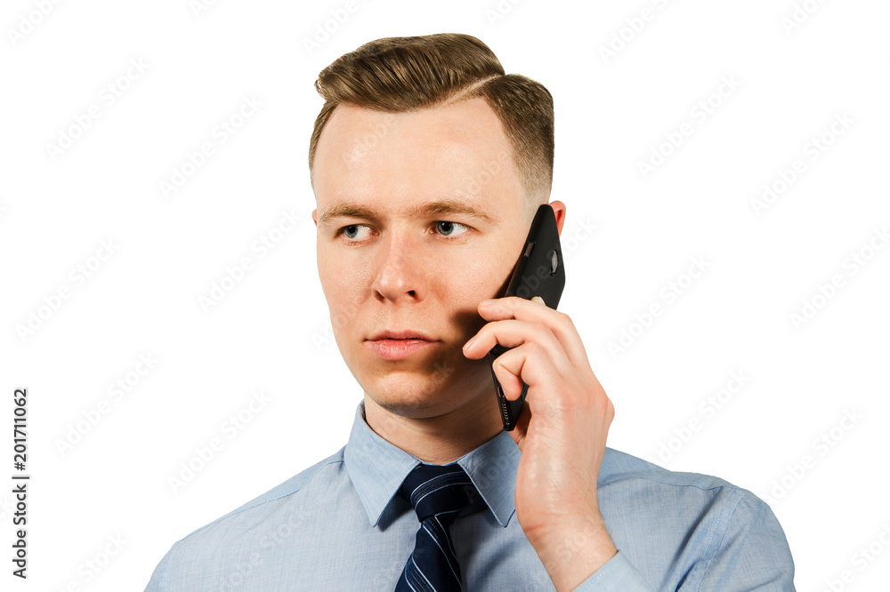 Close-up portrait of young businessman dressed in blue shirt and tie talking on the mobile phone, isolated on white background Close-up portrait of young businessman dressed in blue shirt and tie talking on the mobile phone, isolated on white background