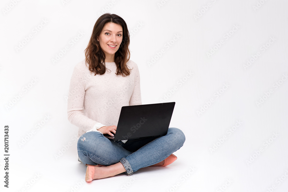 the girl is sitting on the floor with a laptop the girl is sitting on the floor with a laptop