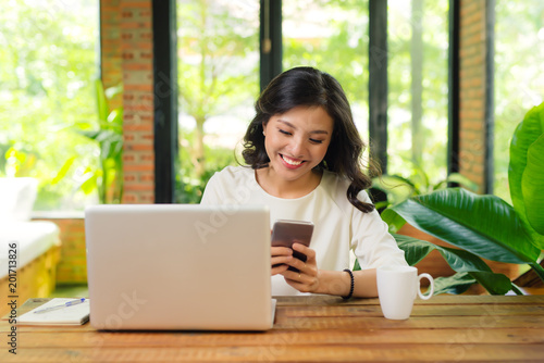 Beautiful asian womon holding a credit card and purchasing online © makistock