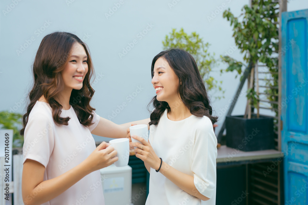 Happy young women friends well-dressed smiling while standing together Happy young women friends well-dressed smiling while standing together