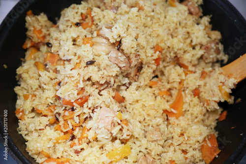 Preparation of rice dishes - pilaf from Uzbekistan. All the contents of the pan are thoroughly mixed, the pilaf is ready.