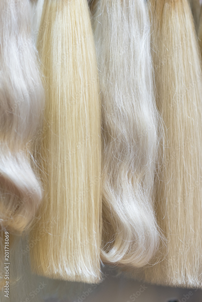 Close up brown, white and another color of hair wigs display in beauty salon.