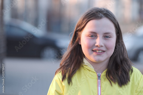 Portrait of a girl on the street in the rays of the setting sun