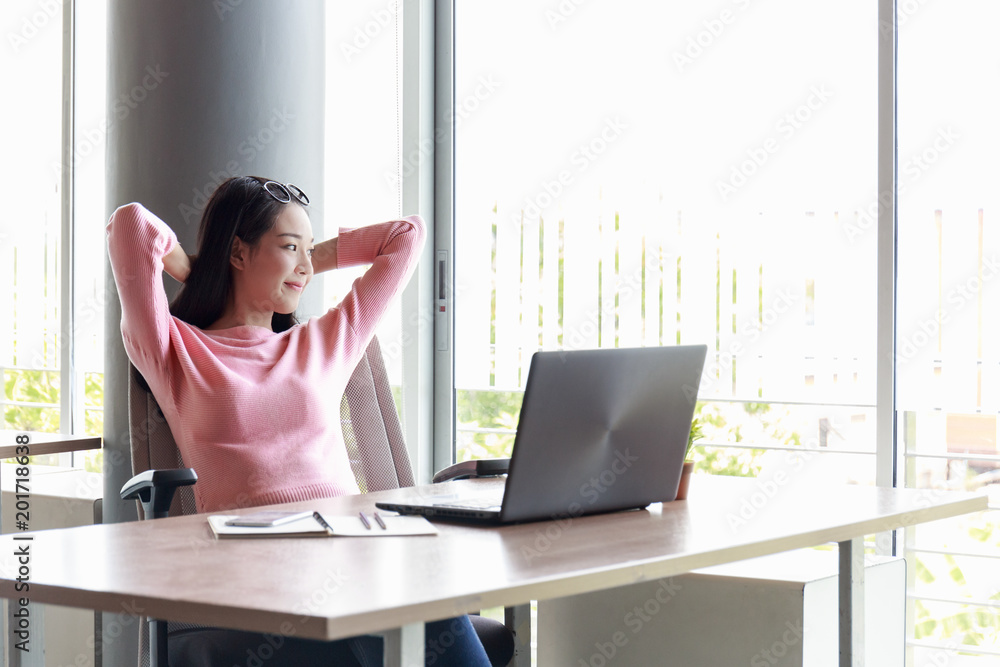 Businesswoman sitting in the office happily. Businesswoman sitting in the office happily.