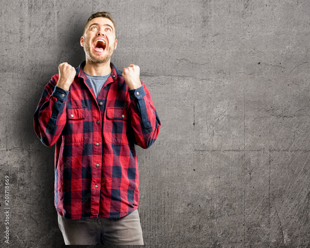 Young handsome man happy and excited expressing winning gesture. Successful and celebrating victory, triumphant Young handsome man happy and excited expressing winning gesture. Successful and celebrating victory, triumphant