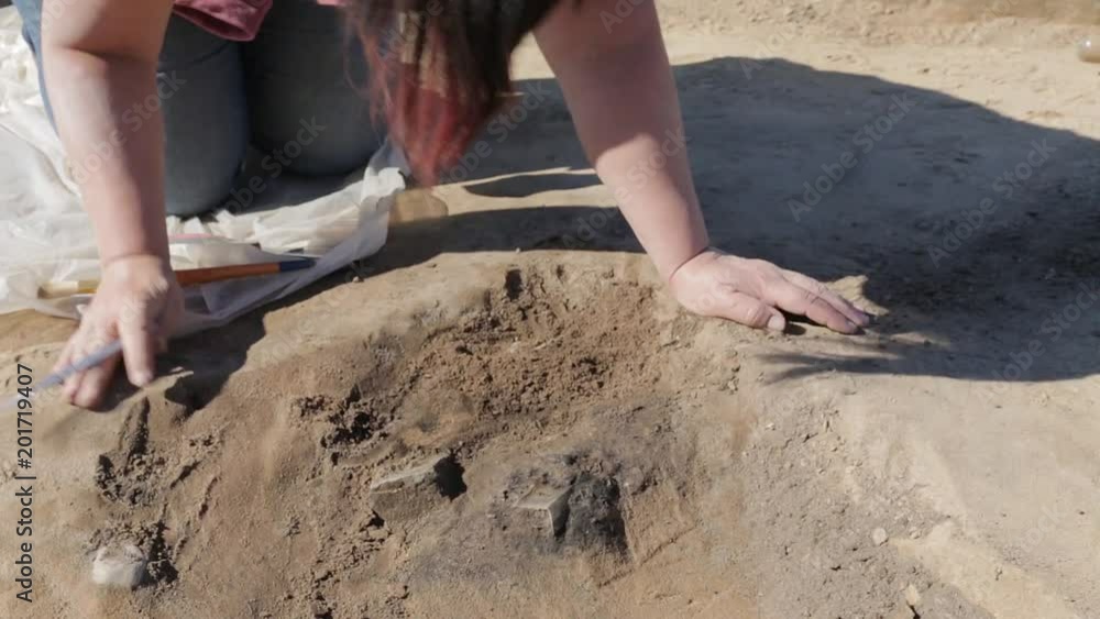 Painstaking and accurate work of the archaeologist to clear the ancient burial