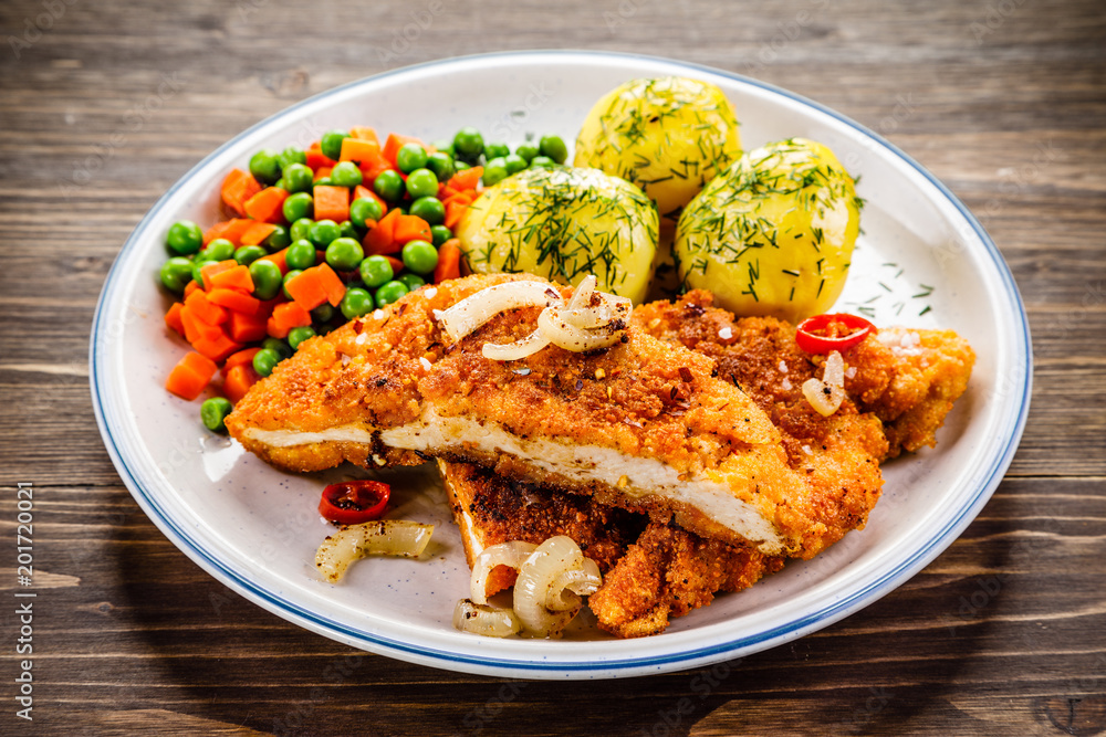 Fried pork chop with potatoes and vegetable salad Fried pork chop with potatoes and vegetable salad