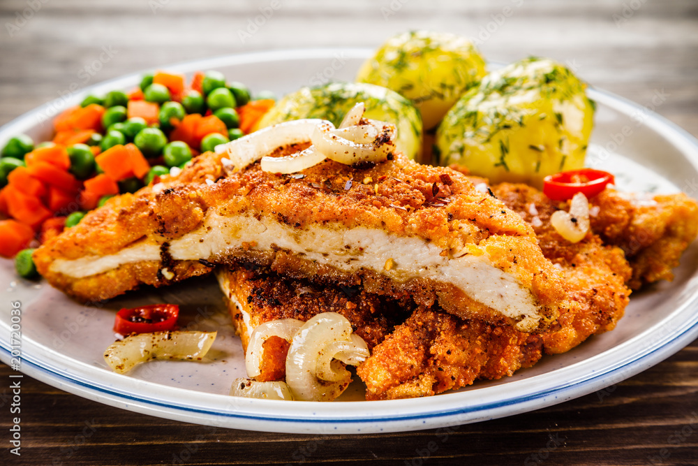 Fried pork chop with potatoes and vegetable salad