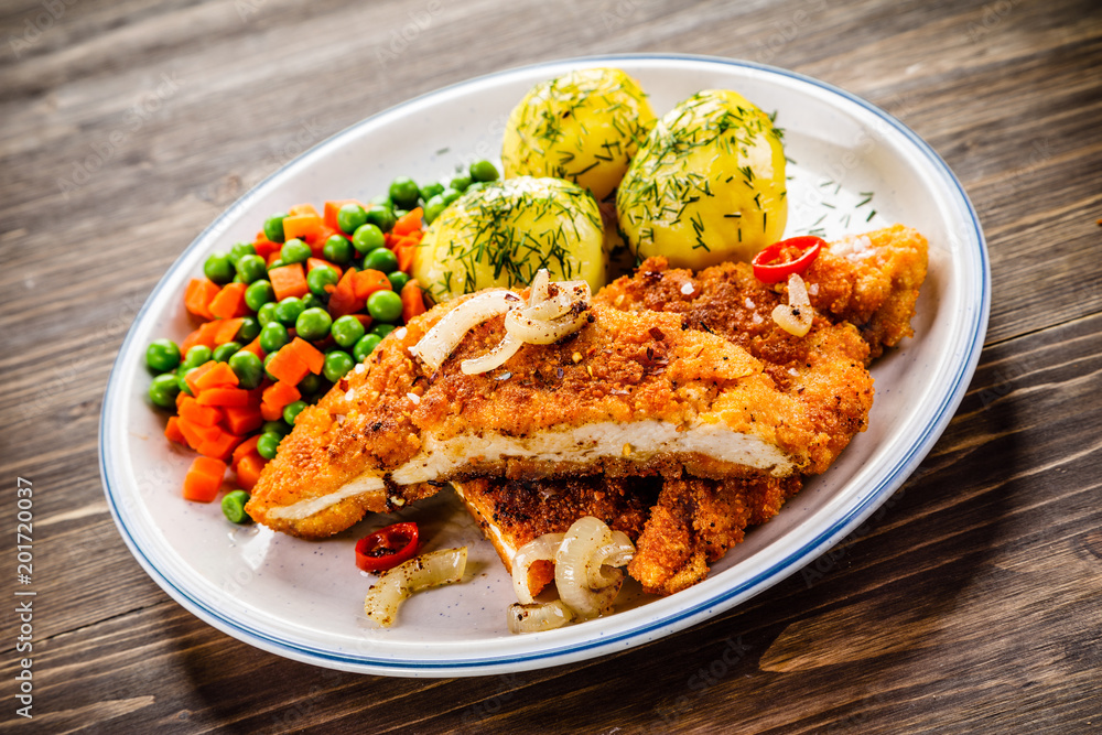 Fried pork chop with potatoes and vegetable salad Fried pork chop with potatoes and vegetable salad
