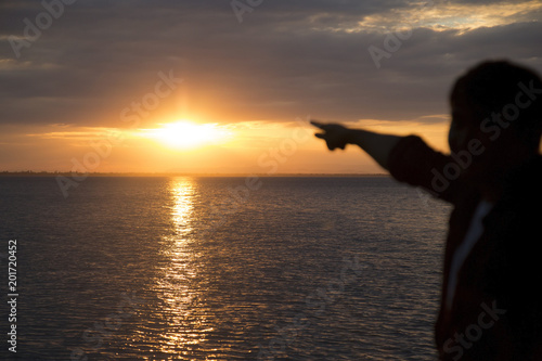 One man looking at the sunset at the river.