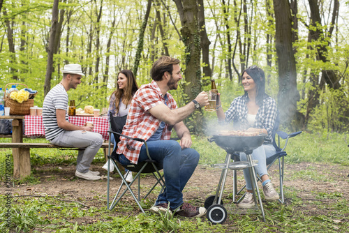 Group of friends making barbecue and having fun outdoor