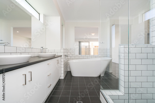 Large modern bathroom interior with large bathtub and luxury fittings.