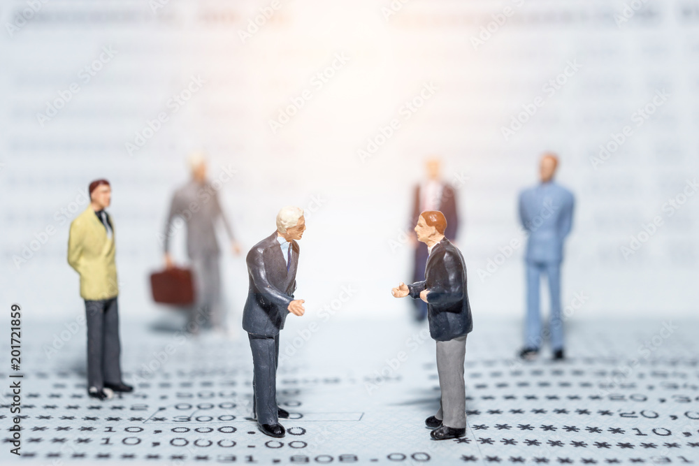 businessman miniature standing around for a meeting on a bank book businessman miniature standing around for a meeting on a bank book