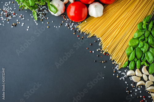 Pasta and ingredients for cooking on dark background, top view