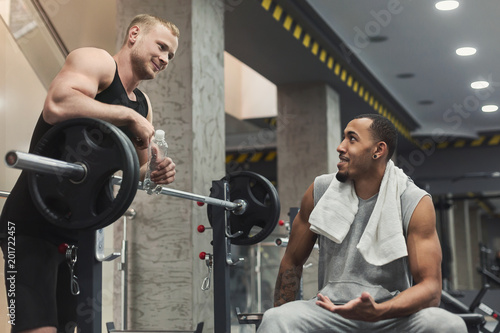 Man and personal trainer exercising with dumbbell photo