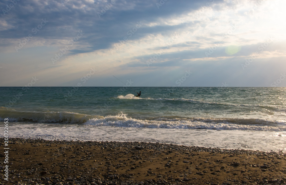 kitesurfer rides a kite-surf on waves of the sea kitesurfer rides a kite-surf on waves of the sea