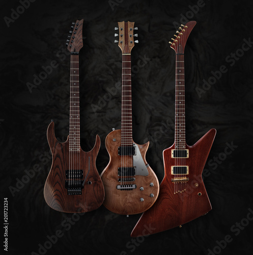 Set of three different shaped electric guitars with natural finish isolated on dark moire background, low key