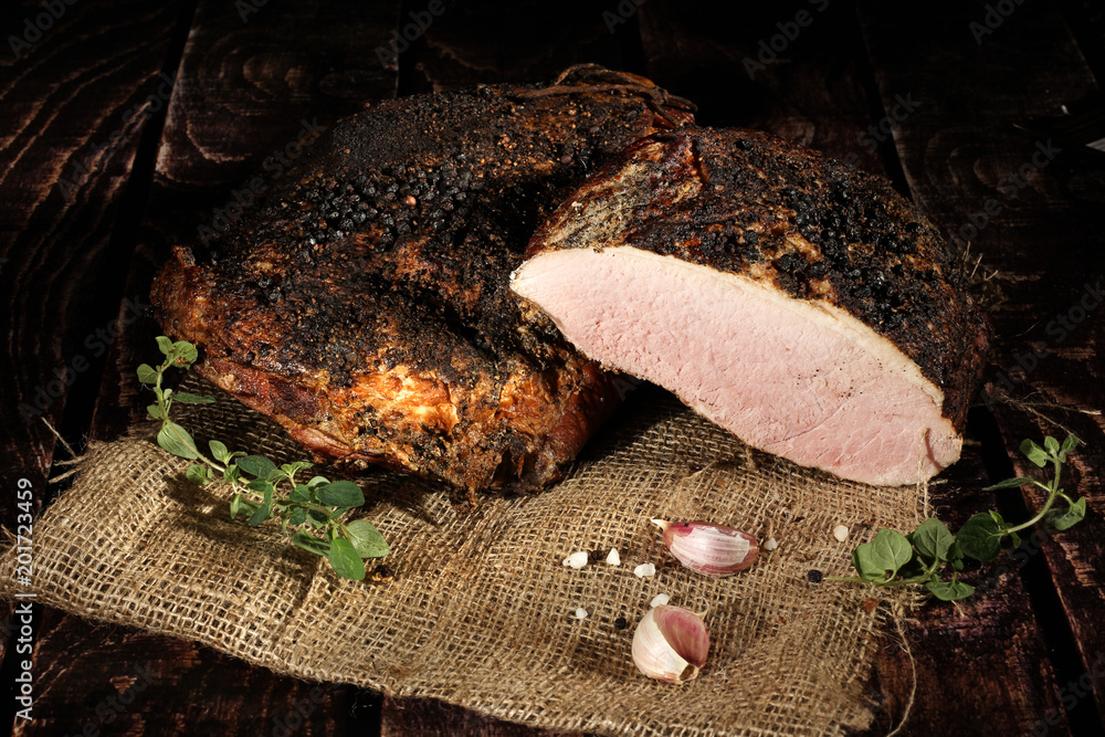 Fototapeta premium Aromatyczne wędzone wędliny. Tradycyjnie wędzone wędliny w kompozycja na lnianym obrusie z ziołami