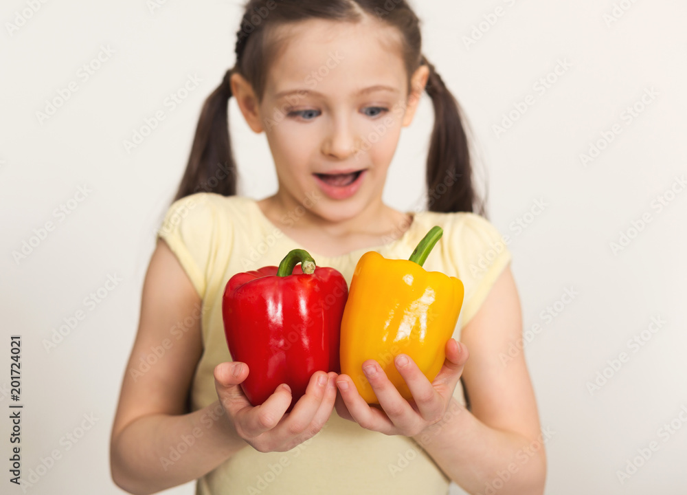 Happy little girl with bell peppers over white background Happy little girl with bell peppers over white background
