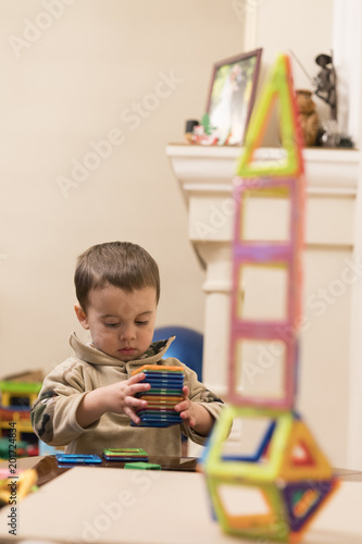 The boy 2 years building a tower from a bright and colorful designer. Intellectual toys. The child plays with a magnetic constructor
