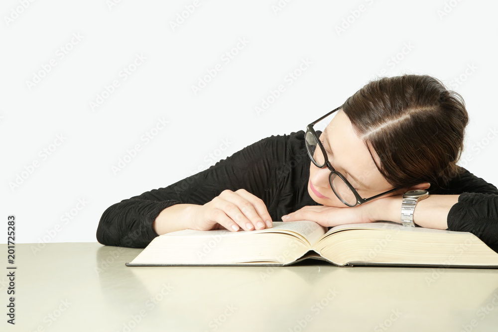 Studio portrait of young woman in front of big book on the table, don't feel like studying concept Studio portrait of young woman in front of big book on the table, don't feel like studying concept