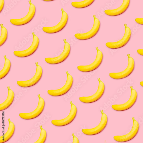 Colorful fruit pattern of yellow bananas on pink background top view