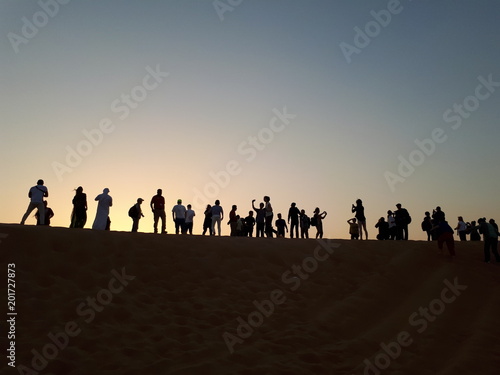 Personen die Sonnenuntergang in der Wüste fotografieren 