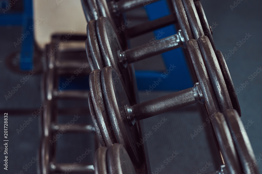 Black dumbbells on the counter in the gym Black dumbbells on the counter in the gym