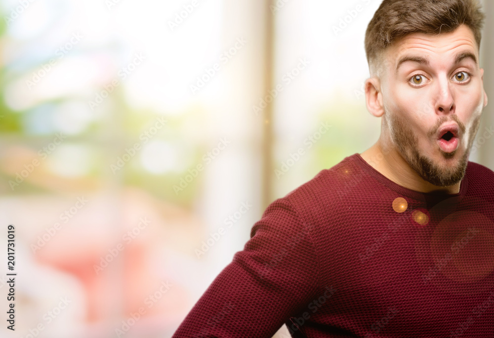 Handsome young man happy and surprised cheering expressing wow gesture Handsome young man happy and surprised cheering expressing wow gesture