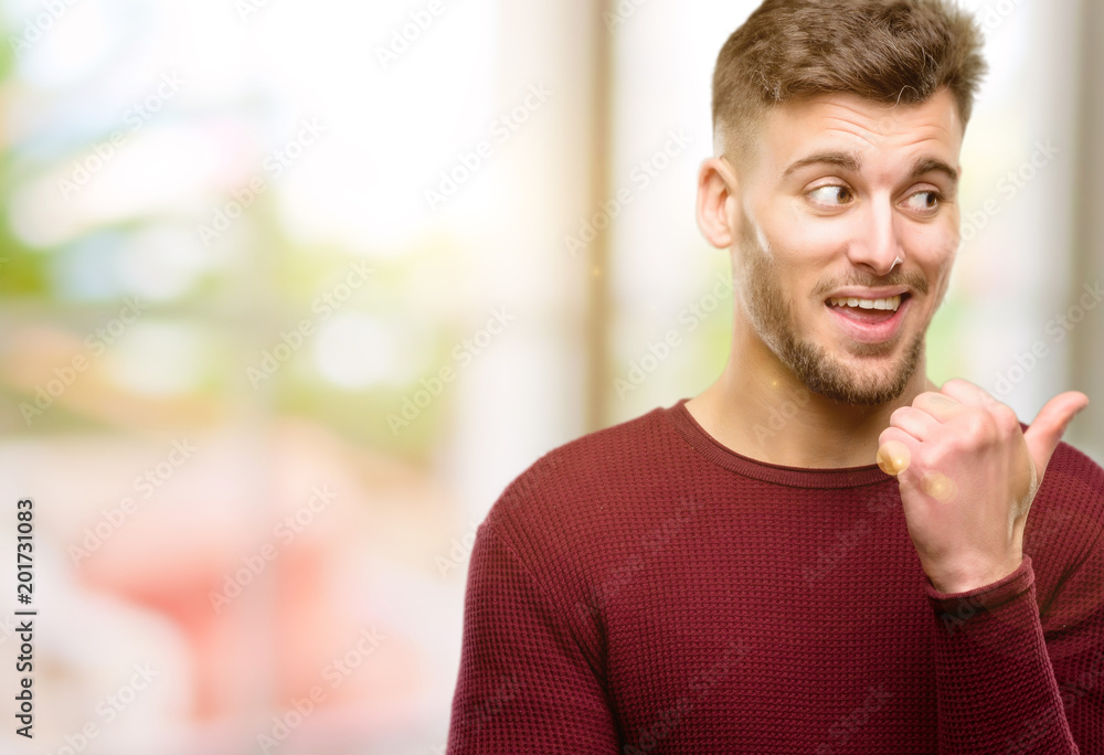 Handsome young man pointing away side with his finger Handsome young man pointing away side with his finger