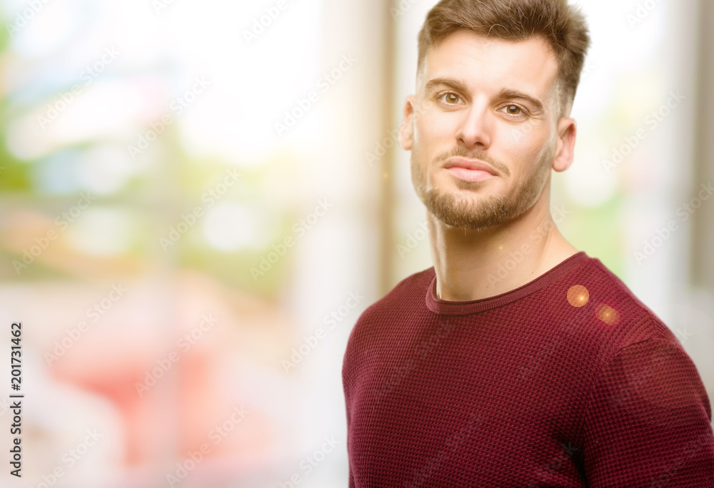 Handsome young man confident and happy with a big natural smile looking at camera Handsome young man confident and happy with a big natural smile looking at camera