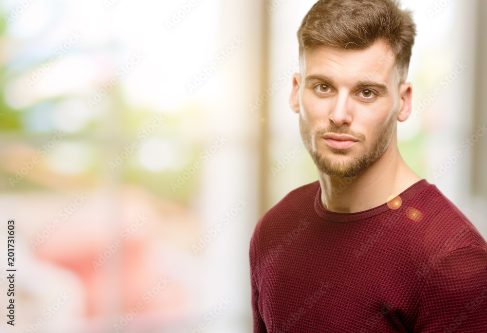 Handsome young man confident and happy with a big natural smile looking at camera Handsome young man confident and happy with a big natural smile looking at camera