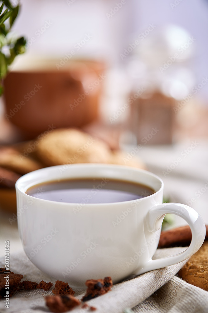 Morning coffee in white cup, chocolate chips cookies on cutting board close-up, selective focus Morning coffee in white cup, chocolate chips cookies on cutting board close-up, selective focus