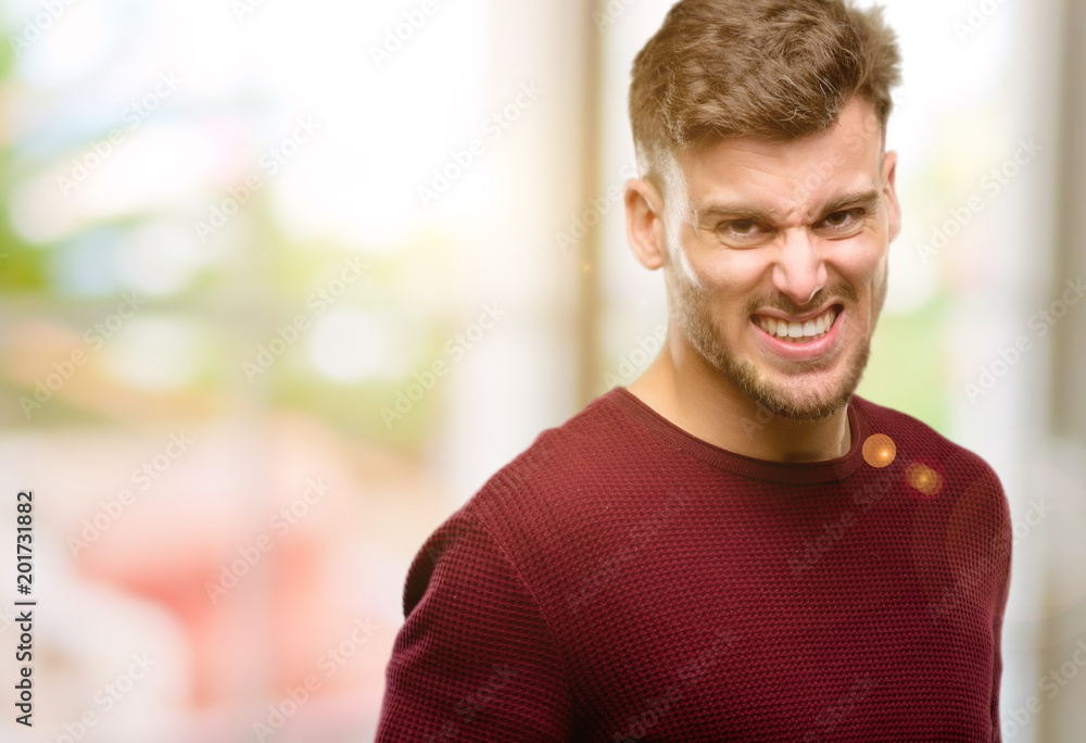 Handsome young man angry and stressful frowns face in dissatisfaction, irritated and annoyed, expressing anger Handsome young man angry and stressful frowns face in dissatisfaction, irritated and annoyed, expressing anger