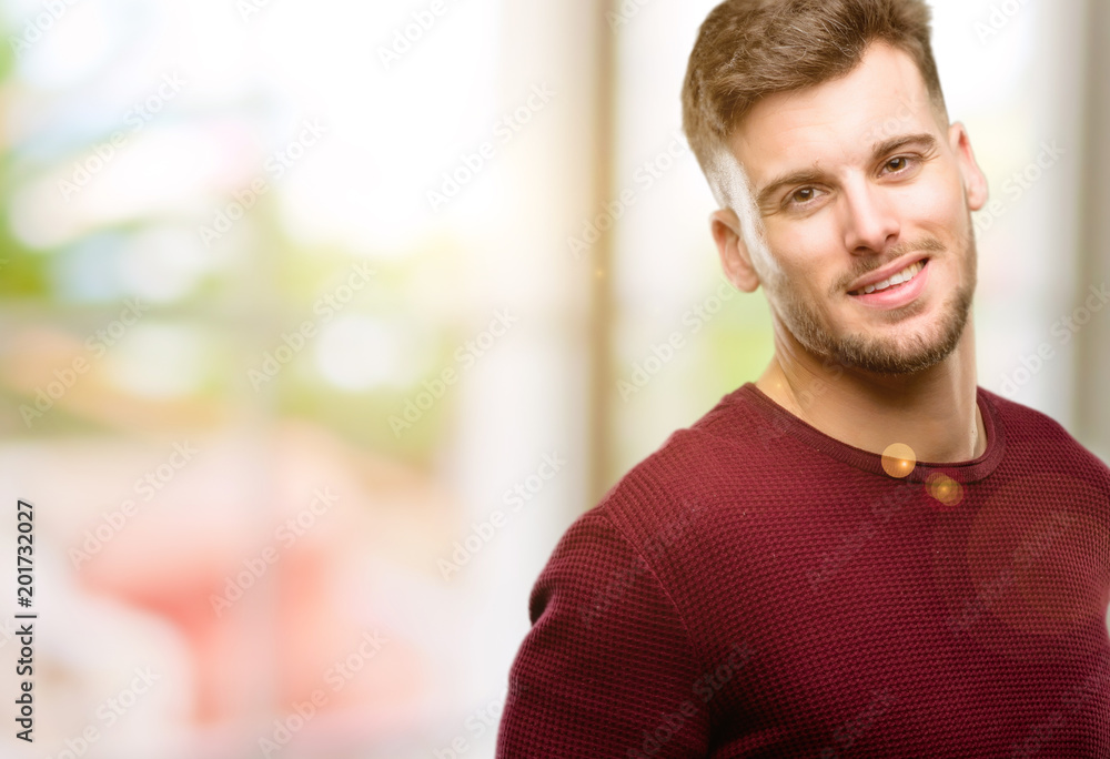Handsome young man confident and happy with a big natural smile laughing, natural expression Handsome young man confident and happy with a big natural smile laughing, natural expression