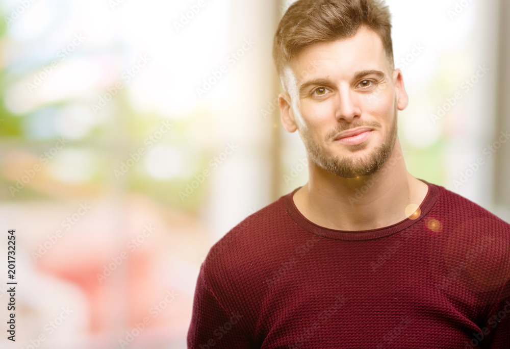 Handsome young man confident and happy with a big natural smile laughing