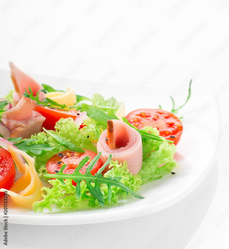 Fresh salad with tomatoes, arugula, cheese and ham on the white plate and white background Fresh salad with tomatoes, arugula, cheese and ham on the white plate and white background