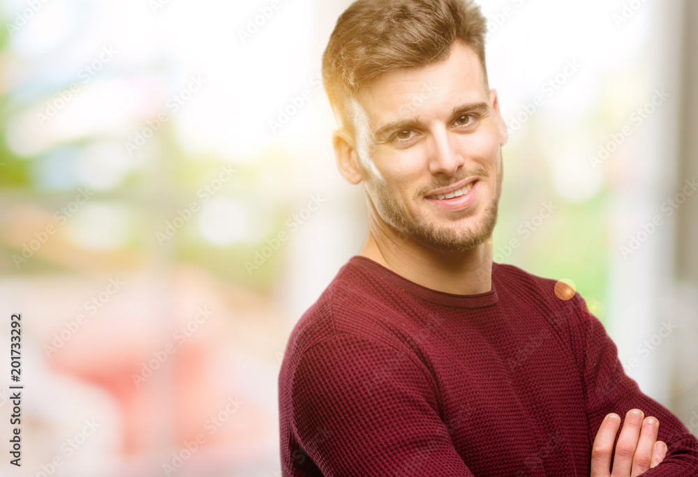 Obraz premium Handsome young man with crossed arms confident and happy with a big natural smile laughing