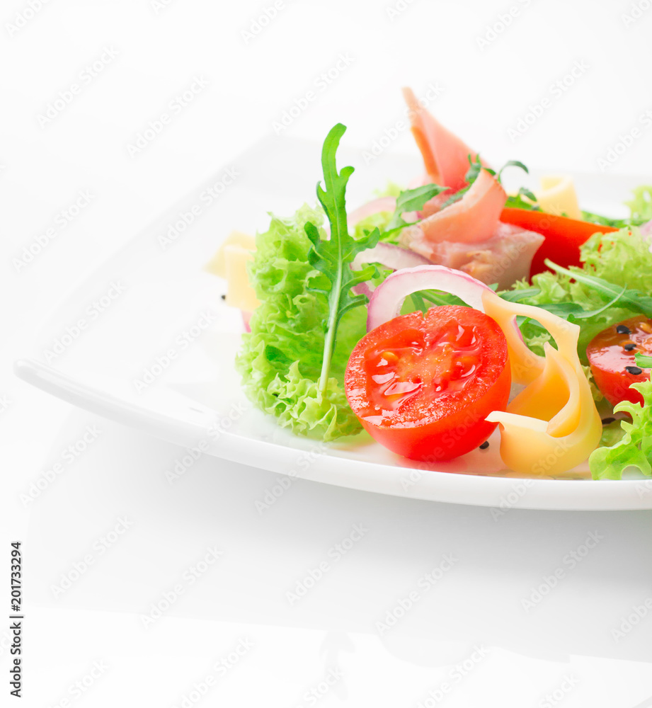 Fresh salad with tomatoes, arugula, cheese and ham on the white plate and white background