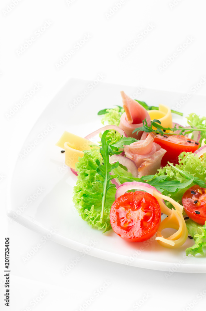 Fresh salad with tomatoes, arugula, cheese and ham on the white plate and white background