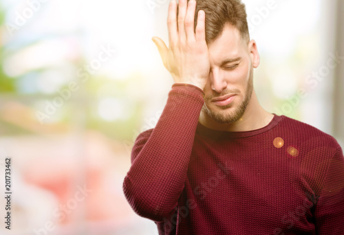 Handsome young man stressful keeping hand on head, tired and frustrated