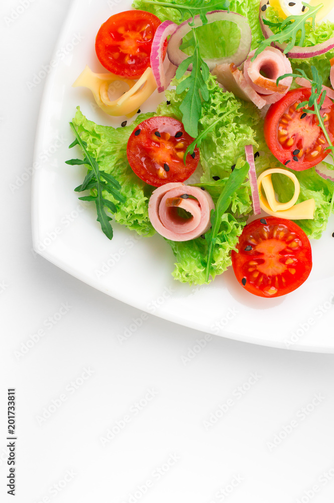 Fresh salad with tomatoes, arugula, cheese and ham on the white plate and white background Fresh salad with tomatoes, arugula, cheese and ham on the white plate and white background