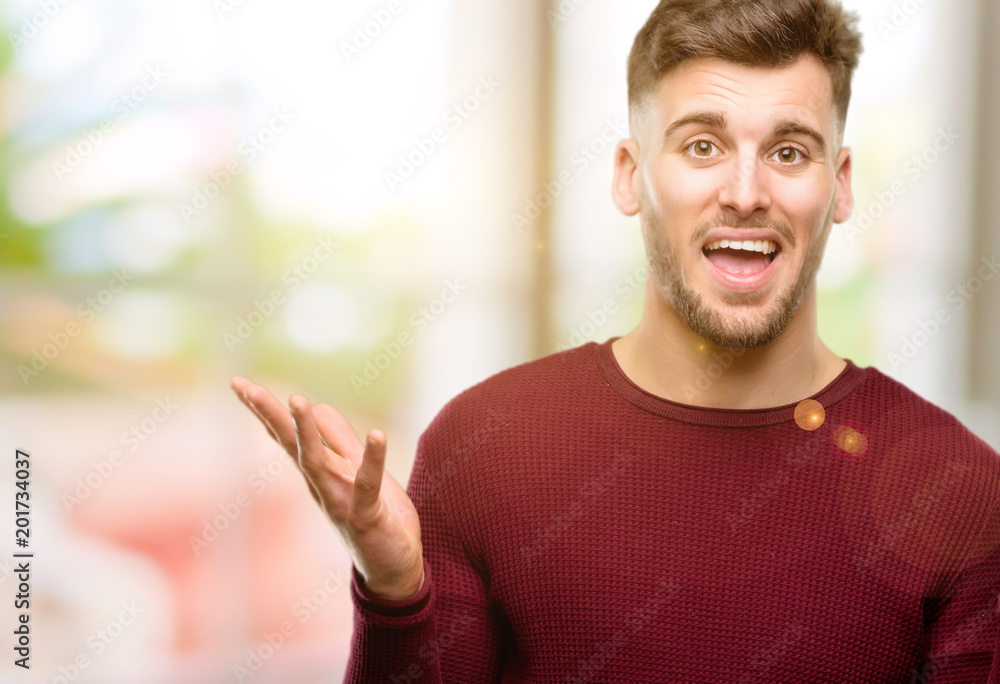 Handsome young man happy and surprised cheering expressing wow gesture Handsome young man happy and surprised cheering expressing wow gesture
