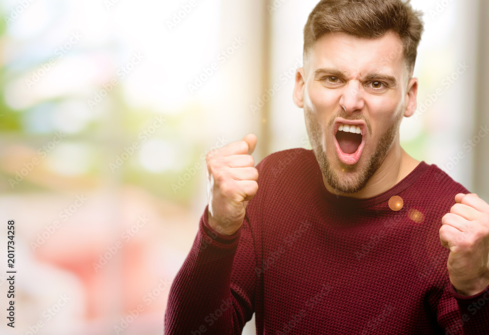 Handsome young man happy and excited celebrating victory expressing big success, power, energy and positive emotions. Celebrates new job joyful Handsome young man happy and excited celebrating victory expressing big success, power, energy and positive emotions. Celebrates new job joyful