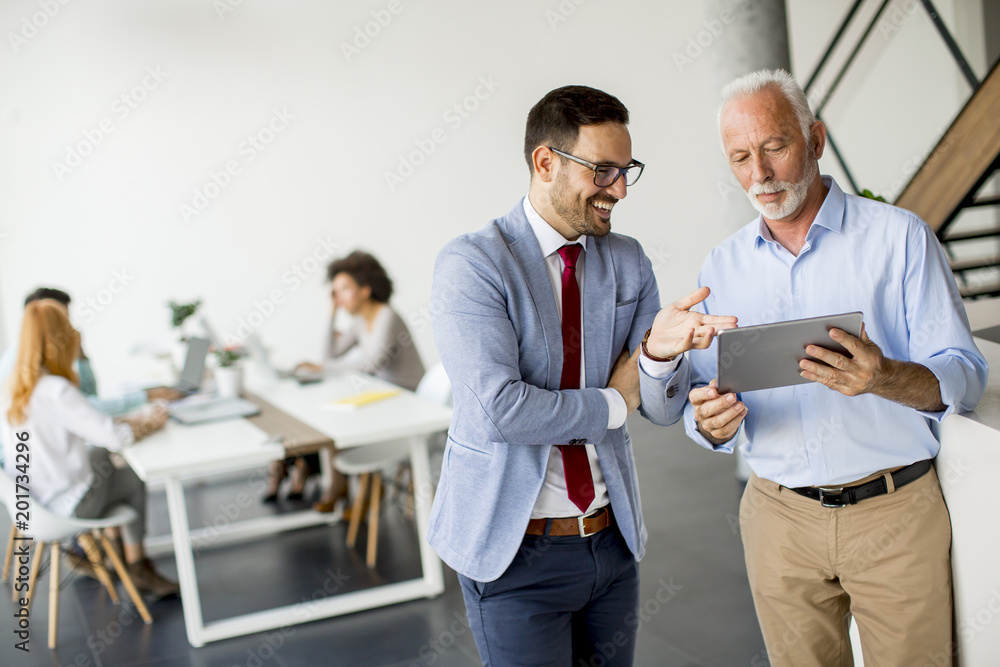 Businessmen with digital tablet in office Businessmen with digital tablet in office