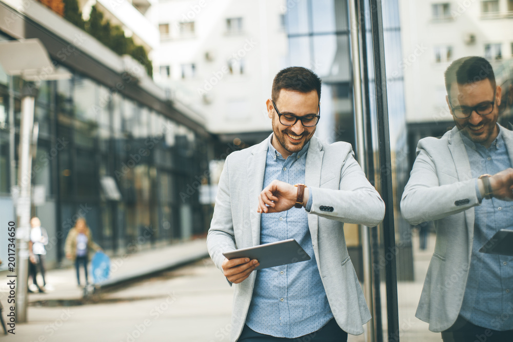 Young businessman with digital tablet by the office building Young businessman with digital tablet by the office building